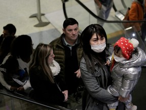 Travellers wearing masks arrive on a direct flight from China at Seattle-Tacoma International Airport on January 23, 2020.