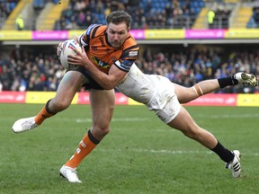 Michael Shenton of Castleford Tigers gets tackled by Matthew Russell of Toronto Wolfpack during the Betfred Super League match between at Emerald Headingley Stadium in Leeds, England, yesterday.  George Wood/Getty Images
