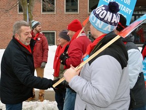 Sam Hammond, president of the Elementary Teachers' Federation of Ontario (ETFO) (left), greets striking teachers and their supporters last Friday at a picket line set up in front of Conservative MPP Bill Walker's constituency office in Owen Sound. 
(Postmedia Network)