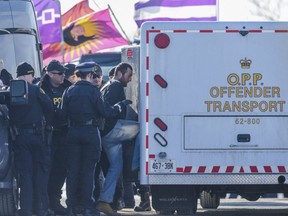 A railway blockade demonstrator is led into an OPP "Offender Transport" vehicle in Tyendinaga, Ontario. ALEX FILIPE