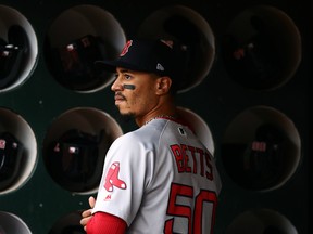 Mookie Betts #50 of the Boston Red Sox stands in the dugout before their game against the Oakland Athletics at Oakland-Alameda County Coliseum on April 03, 2019 in Oakland, California.