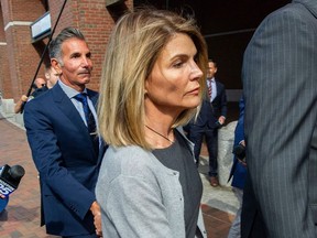 In this file photo taken Aug. 27, 2019, actress Lori Loughlin and husband Mossimo Giannulli exit the Boston Federal Court house after a pre-trial hearing with Magistrate Judge Kelley at the John Joseph Moakley US Courthouse in Boston.