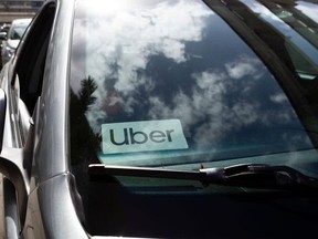 An Uber sticker is seen on a car windshield.