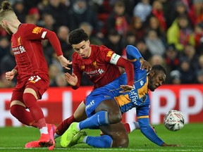 Shrewsbury Town’s Grenadian defender Aaron Pierre (R) vies with Liverpool’s English midfielder Curtis Jones (C) during the English FA Cup fourth-round reply football match between Liverpool and Shrewsbury Town at Anfield in Liverpool on Tuesday. Getty Images.