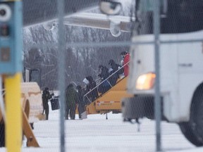 Passengers disembark an airplane carrying Canadian citizens flown out from the coronavirus zone in Wuhan, China, after arriving at CFB Trenton in Trenton on February 7, 2020. (Photo by Chris Wattie / AFP)