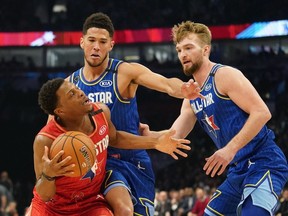Team Giannis guard Kyle Lowry of the Toronto Raptors drives against Team LeBron forward Domantas Sabonis of the Indiana Pacers and Devin Booker of the Phoenix Suns during the third quarter of the 2020 NBA All Star Game at United Center.