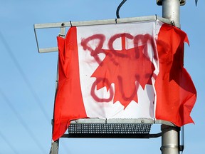 A Canadian flag hangs upside down at a railway blockade as part of protests against British Columbia's Coastal GasLink pipeline, in Edmonton February 19, 2020. (REUTERS/Codie McLachlan)