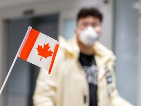 A traveller wears a mask at Pearson airport arrivals, shortly after Toronto Public Health received notification of Canada's first presumptive confirmed case of novel coronavirus, in Toronto, Ontario, Canada on Jan. 26, 2020.
