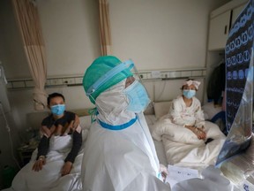 A medical worker in protective suit inspects a CT scan image at a ward of Wuhan Red Cross Hospital in Wuhan, the epicentre of the novel coronavirus outbreak, in Hubei province, China February 24, 2020. Picture taken February 24, 2020.