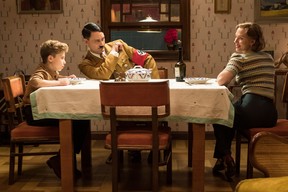 Jojo (Roman Griffin Davis) has dinner with his imaginary friend Adolf (writer/director Taika Waititi) and his mother, Rosie (Scarlett Johansson), in the Second World War satire “Jojo Rabit.” Kimberley French/Twentieth Century Fox
