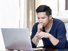 seriously confident asian young freelancer in smart casual working and concentrated on laptop sitting on desk in modern office ,co-working space or at home with copy space, webinar over the internet