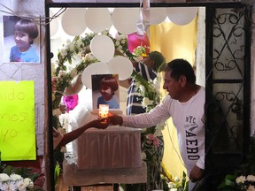 People light candles near the coffin of Fatima Cecilia Aldrighett, 7, at her house in Mexico City, February 17, 2020. (REUTERS/Edgard Garrido)