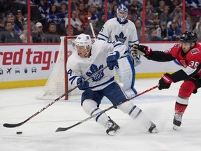 Toronto Maple Leafs defenseman Tyson Barrie skates with the puck away from Ottawa Senators center Colin White in the second period at the Canadian Tire Centre.