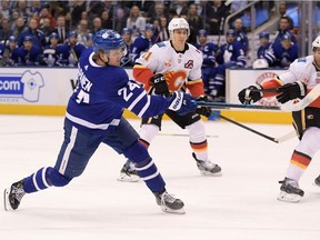 Toronto Maple Leafs forward Kasperi Kapanen shoots the puck past Calgary Flames defenseman TJ Brodie and forward Mikael Backlund in the second period at Scotiabank Arena.