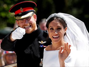 Prince Harry gestures next to his wife Meghan as they ride a horse-drawn carriage after their wedding ceremony at St. George's Chapel in Windsor Castle in Windsor, May 19, 2018. REUTERS/Damir Sagolj/File Photo