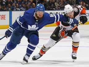 Leafs defenceman Jake Muzzin (left) battles Anaheim Ducks’ Ondrej Kase at Scotiabank Arena Friday night. The Leafs won 5-4 in OT. Getty images