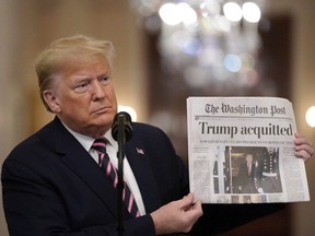 U.S. President Donald Trump holds a copy of The Washington Post as he speaks in the East Room of the White House one day after the U.S. Senate acquitted him on two articles of impeachment, in Washington, D.C., on Feb. 6, 2020.