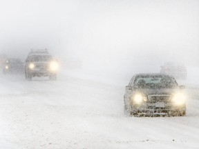 Cars drive through driving snow on Hwy. 401 in Pickering.