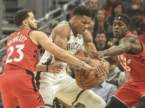 Raptors guard Fred VanVleet (left) and forward Pascal Siakam put pressure on Milwaukee Bucks forward Giannis Antetokounmpo during a game in November. (USA TODAY Sports)