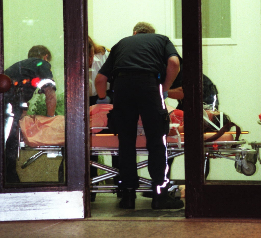  Emergency workers tend to a 14-year-old girl in the lobby of her Sheppard Ave. E. apartment building after she and her 18-year-old sister, Tina Wu, were stabbed by an intruder in July 2000. (Sun file photo)