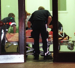 Emergency workers tend to a 14-year-old girl in the lobby of her Sheppard Ave. E. apartment building after she and her 18-year-old sister, Tina Wu, were stabbed by an intruder in July 2000. (Sun file photo)