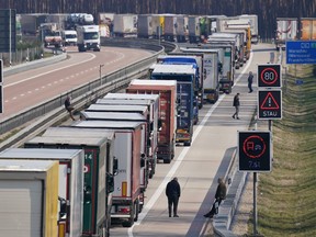 BRIESEN, GERMANY - MARCH 17: Truck drivers stand next to their trucks among a line of trucks stretching over 40km on the A12 highway towards Germany's border to Poland on March 17, 2020 near Briesen, Germany. The Polish government recently imposed heavy restrictions on its border to Germany in an effort to stem the spread of the coronavirus and had promised cargo would still be allowed to cross. (Photo by Sean Gallup/Getty Images)