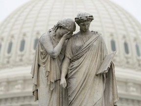 Grief holds her covered face against the shoulder of History and weeps in "mourning" as depicted at the Peace Monument in front of the U.S. Capitol in Washington, on March 23, 2020. (Reuters)