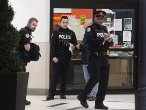 Toronto Police officers are pictured on March 29, 2020, after they responded to a call at 345 Bloor St. E. (Stan Behal, Toronto Sun)