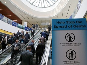 Visitors pass a sign warning about the spread of germs at the Prospectors and Developers Association of Canada annual conference in Toronto on March 1, 2020. (Reuters)