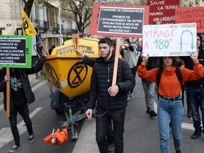 Protesters hold banners reading "180 degree turn " and "coronavirus pandemic, the first step in the collapse of our civilization if we do not revolt today" during a recent demonstration for climate change in Bordeaux, France, despite government recommendations to limit gatherings amid the outbreak of COVID-19. (Photo by AFP, via Getty Images)