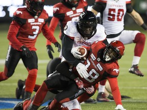 Calgary Stampeders' Terry Williams is tackled by the Ottawa Redblacks' Chris Ackie. (SUN FILES)