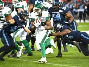 Saskatchewan Roughriders running back William Powell, center, is tackled by Toronto Argonauts defensive end Freddie Bishop III, right, during first half CFL football game action in Toronto on Saturday, September 28, 2019. THE CANADIAN PRESS/Jon Blacker