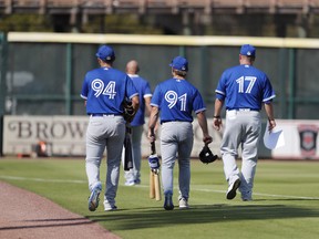 Members of the Toronto Blue Jays leave the field after a spring training baseball game against the Pittsburgh Pirates, Thursday, March 12, 2020, in Bradenton, Fla. (AP Photo/Carlos Osorio)