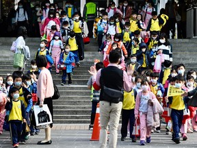 Children wearing face masks leave their elementary school at the end of the day in Xindian district, New Taipei City on March 3, 2020. - The world has entered uncharted territory in its battle against the deadly coronavirus, the UN health agency warned, as new infections dropped dramatically in China on March 3 but surged abroad with the US death toll rising to six. (Photo by Sam Yeh / AFP) (Photo by SAM YEH/AFP via Getty Images)