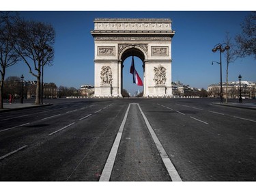 A french flag is under the Arc de Triomphe, on March 19, 2020 in Paris, as a strict lockdown is in effect in France to stop the spread of COVID-19, caused by the novel coronavirus.