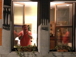 A man stands at the window of an appartment clapping as Belgium imposes a lockdown to slow down the spread of the novel coronavirus, COVID-19, in Brussels, on March 19, 2020; - Citizens are obliged to stay at home in Belgium, France, Italy and Spain, except for medical attention, getting exercise or essential shopping, as a lockdown is imposed in these countries to stop the spread of the virus. (Photo by François WALSCHAERTS / AFP) (Photo by FRANCOIS WALSCHAERTS/AFP via Getty Images)
