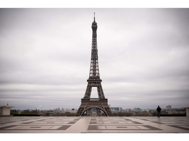 A man walks on the deserted Trocadero square in front of the Eiffel Tower on March 21, 2020 in Paris on the fifth day of a strict nationwide lockdown seeking to halt the spread of the COVID-19 infection caused by novel coronavirus, with excursions from the home limited to buying food, visiting the doctor, walking the dog or going for a solitary jog.