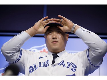 Toronto Blue Jays newly signed pitcher Hyun-Jin Ryu fixes his hat after putting on his Toronto Blue Jays uniform for the first time at a press conference announcing his signing to the team, in Toronto, Friday, Dec. 27, 2019.