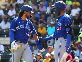 Toronto Blue Jays shortstop Bo Bichette (11) is congratulated by designated hitter Lourdes Gurriel Jr. (13) against the Pittsburgh Pirates at LECOM Park. (Kim Klement-USA TODAY Sports)