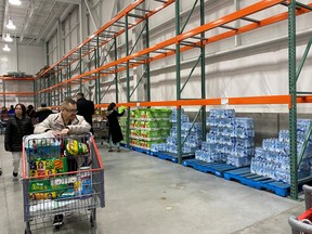 Shoppers pass a row of empty shelving where toilet paper is usually stacked, as the number of coronavirus cases grows worldwide, at a Costco store in Toronto, Ontario, Canada March 13, 2020.  REUTERS/Chris Helgren