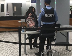 A woman goes through security at Toronto City Hall.
