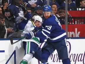 Maple Leafs forward Kyle Clifford takes Tyler Toffoli of the Vancouver Canucks into the boards during a recent game. (Claus Andersen/Getty Images)