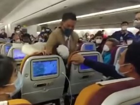 A video shows an irate woman put in a headlock after she reportedly coughed on a plane during a coronavirus check at Shanghai Pudong Airport. (YouTube screengrab)