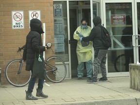 People waiting to get into the South Riverdale Community Health Centre and the demarcation line close to the front entrance, which nobody seemed to adhering to, on Wednesday, March 25, 2020. Jack Boland/Toronto Sun