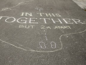 A message "in this together but 2m apart " is written on the driveway of a n Ajax home on Sunday, March 22, 2020. (Veronica Henri/Toronto Sun/Postmedia Network)