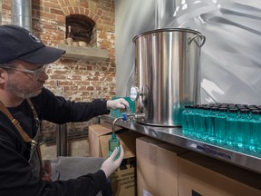 A worker at Spirit of York distillery helps create a recipe for hand sanitizer during the COVID-19 pandemic. The distillery is selling the hand sanitizer bottles for $3, with proceeds to local food banks. They're providing them free to seniors over 65 and to low-income people. SUPPLIED/LAURA WARREN-CAUSTON