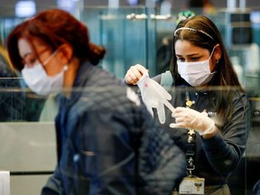 Colombian migration office staff wear protective face masks to avoid contracting coronavirus, at El Dorado international airpot in Bogota, Colombia March 5, 2020.