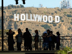 Tourists are silhouetted against the Hollywood sign on June 28, 2013 in Los Angeles.