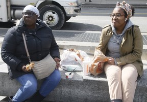 Eating a take-out lunch on a bench near Yonge-Dundas Square on Friday, March 20, 2020. (Veronica Henri/Toronto Sun/Postmedia Network)