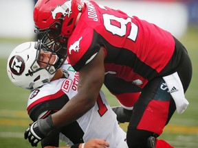 Calgary Stampeders Micah Johnson brings down quarterback Trevor Harris of the Ottawa Redblacks during a 2016 game. Johnson was penalized on the play for roughing the passer. (AL CHAREST/POSTMEDIA NETWORK FILES)